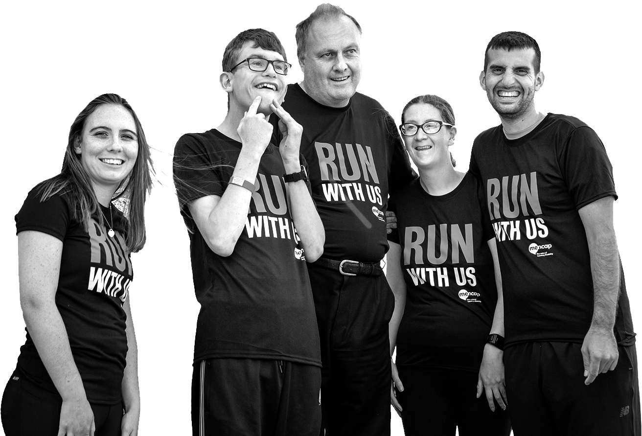 Group of people stood together smiling. They are all wearing "Run with us" t-shirts.