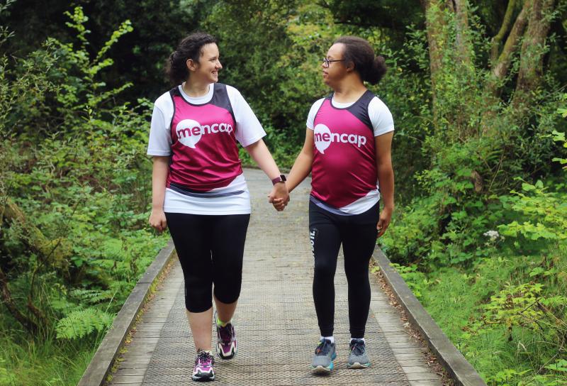 Two Mencap runners waving and smiling