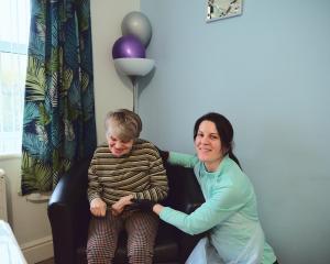 A female support worker smiles as she cares for a lady with a learning disability